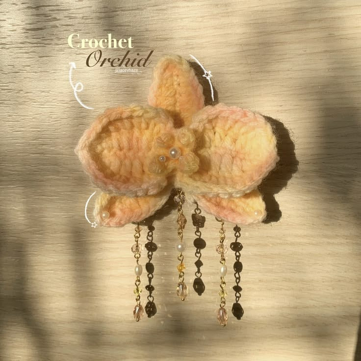 Handmade crochet butterfly hair clip in pastel pink and yellow with pearl bead hanging chains, aesthetic hair accessory for girls and women by Verity.