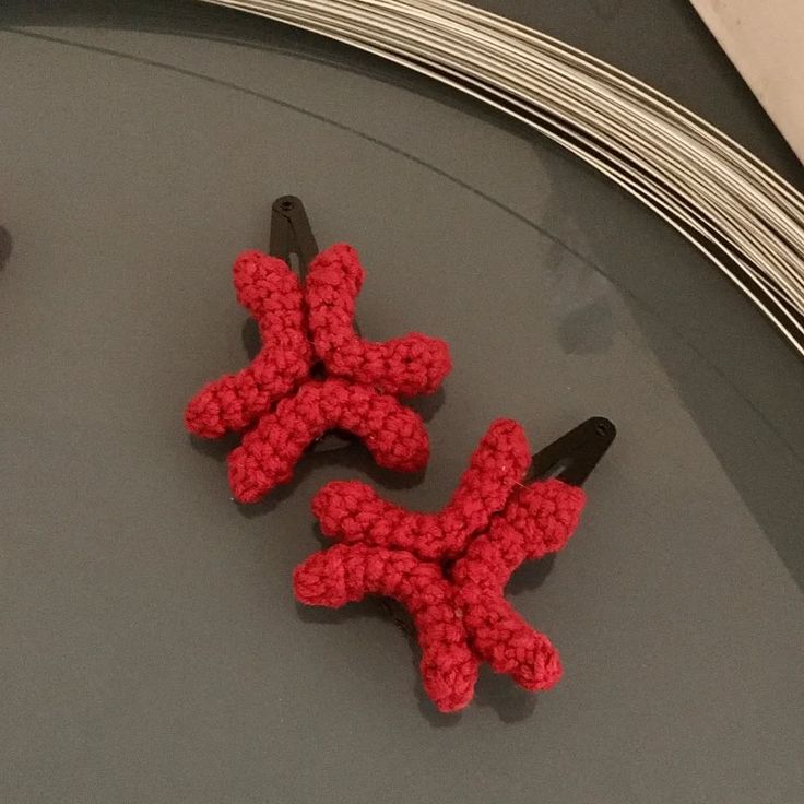 Handmade crochet red bow hair clip worn in brown hair.