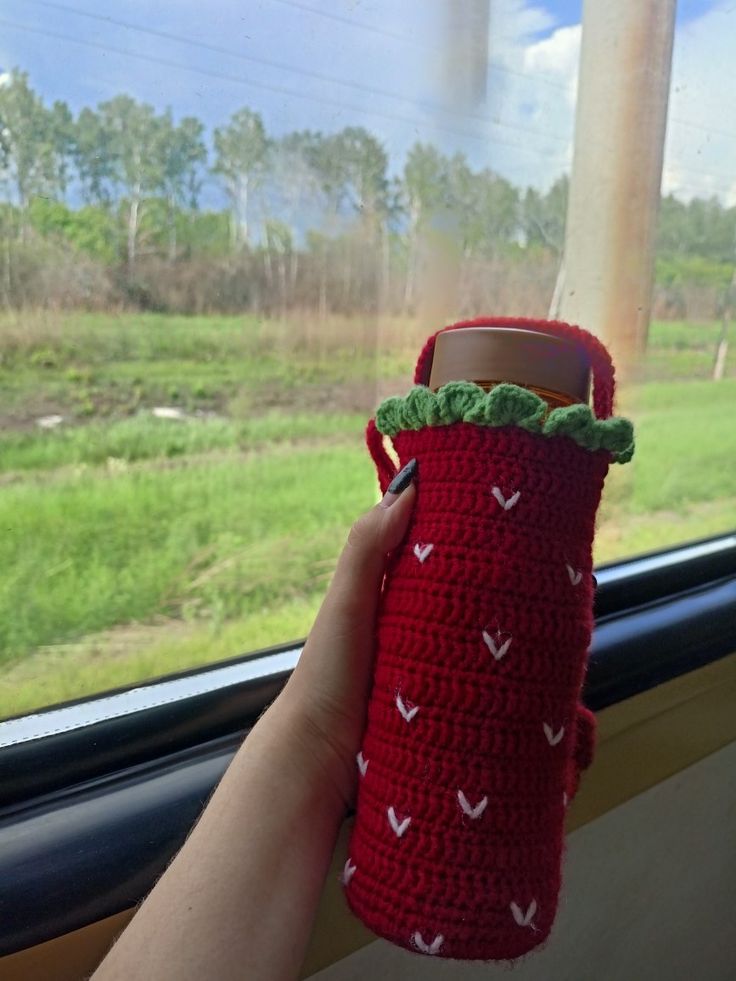 Handmade crochet strawberry bottle cover with red and green knitted design, cute water bottle sleeve